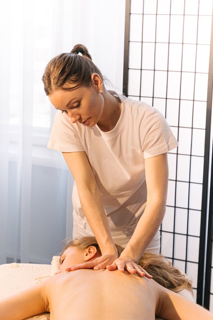 Experienced masseuse providing a relaxing back massage in a tranquil spa setting.